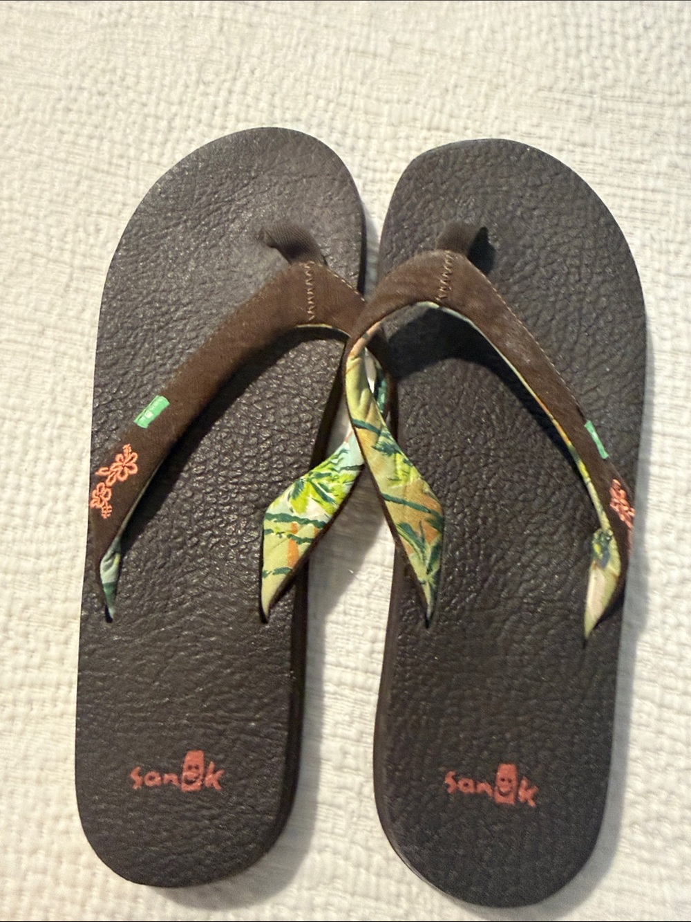 Brown sanuk flip flops with cute flower detail